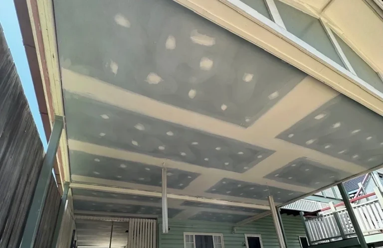 Outdoor covered area ceiling with plasterboard joints set and prepared for finishing.