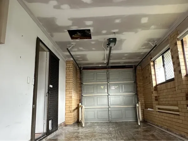 Garage ceiling with plasterboard repairs and joint compound applied.