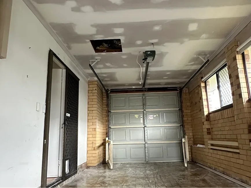 Garage ceiling with plasterboard repairs and joint compound applied.
