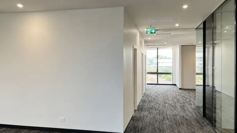 Finished commercial plastering in a modern office fit-out with smooth walls and ceiling.
